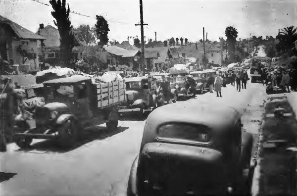 Caravan of trucks loaded with baggage and private cars ready to leave a Control Station in Los Angeles