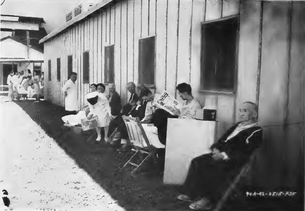 Convalescing patients rest in the shade on the lawn behind the center hospital at Puyallup (Washington) Assembly Center