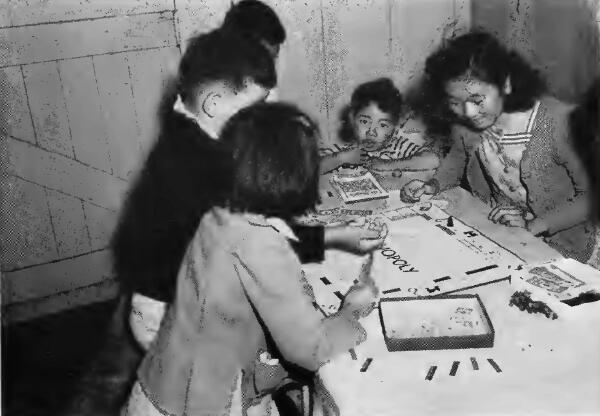A youthful group intensely interested in a game of Monopoly at Santa Anita (California) Assembly Center