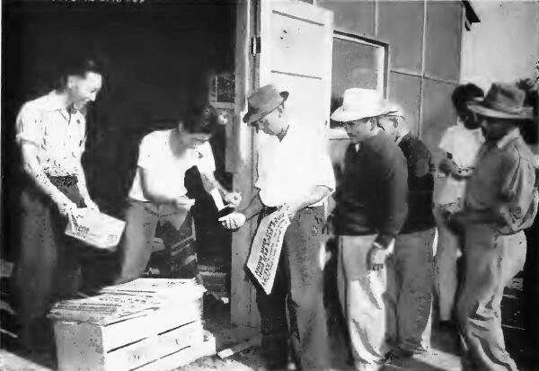 Evacuees buying San Francisco morning papers at Turlock (California) Assembly- Center
